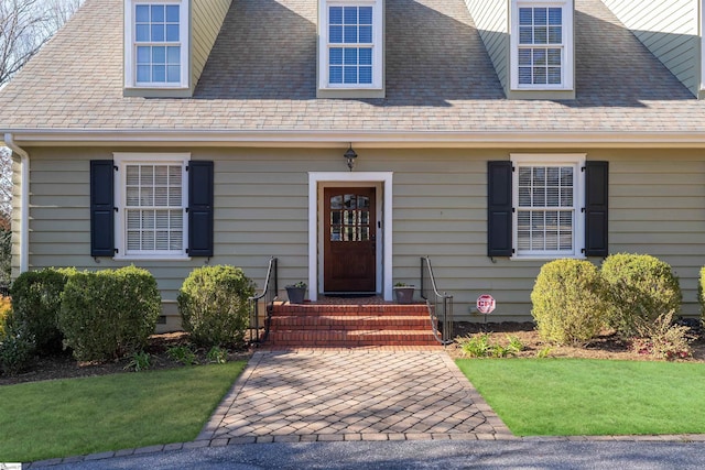 view of front of property with a front yard and roof with shingles