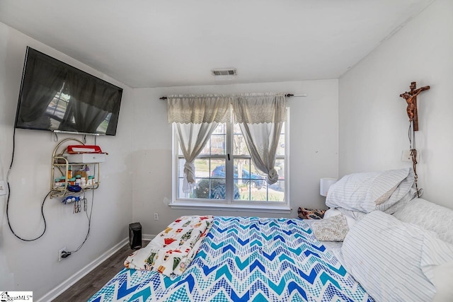 bedroom with baseboards, visible vents, and dark wood finished floors