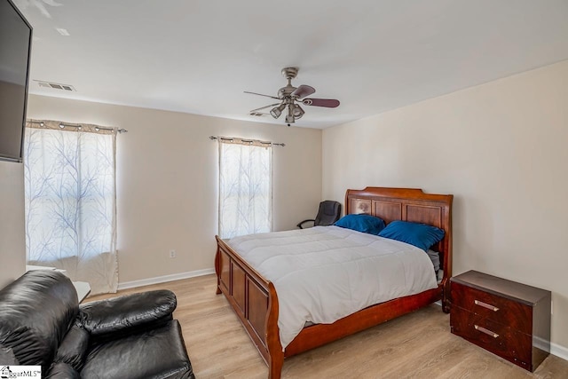 bedroom featuring light wood finished floors, baseboards, visible vents, and ceiling fan