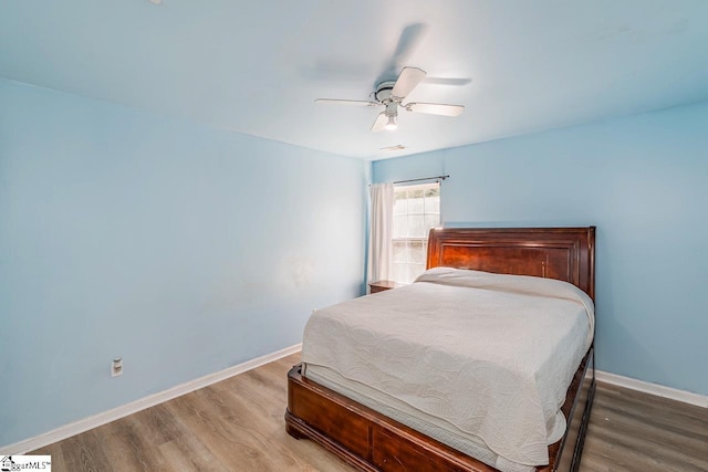 bedroom with baseboards, ceiling fan, and wood finished floors