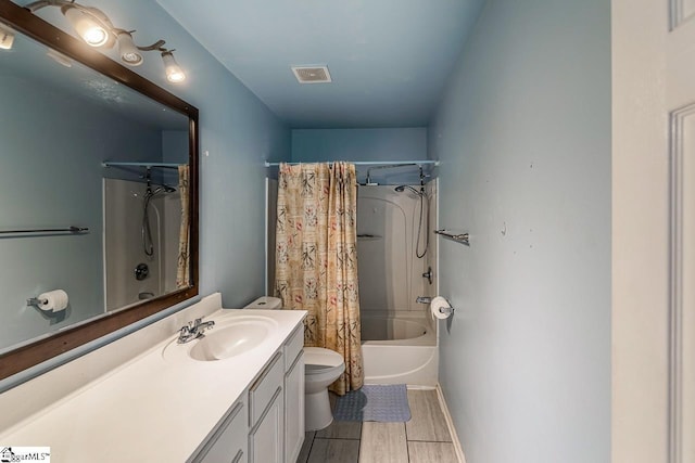 full bath with shower / bath combo, visible vents, toilet, wood finish floors, and vanity