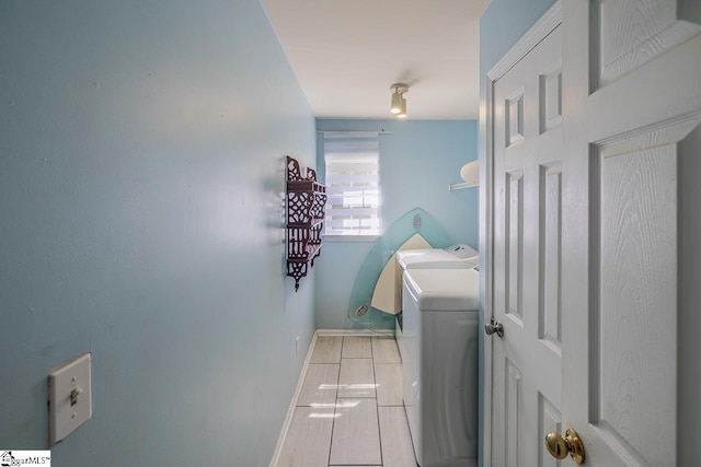 washroom with baseboards, washing machine and dryer, and laundry area