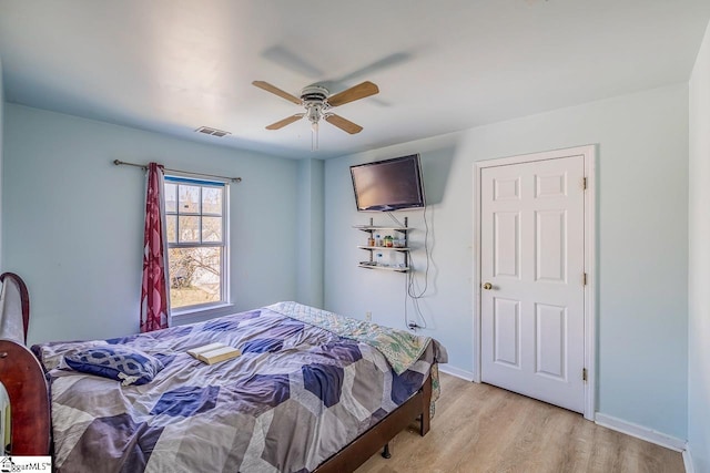 bedroom with light wood-style flooring, baseboards, ceiling fan, and visible vents