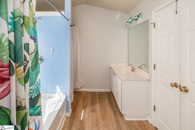 full bath featuring vanity, lofted ceiling, a tub, a shower with shower curtain, and wood finished floors