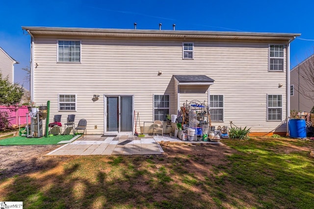 back of house featuring a lawn, fence, and a patio