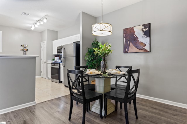 dining space with baseboards, visible vents, and light wood-style flooring