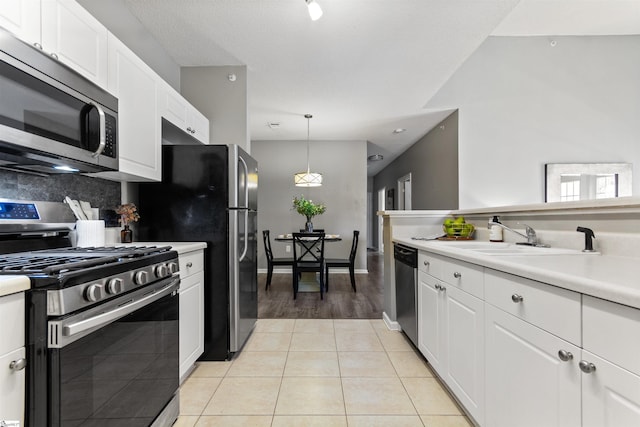 kitchen featuring white cabinetry, light countertops, a sink, and appliances with stainless steel finishes