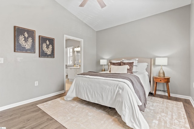 bedroom with baseboards, lofted ceiling, wood finished floors, and ensuite bathroom