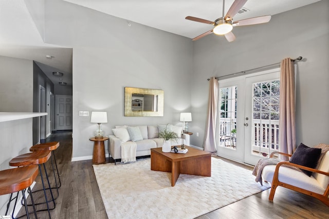 living area featuring dark wood-style floors, ceiling fan, and baseboards