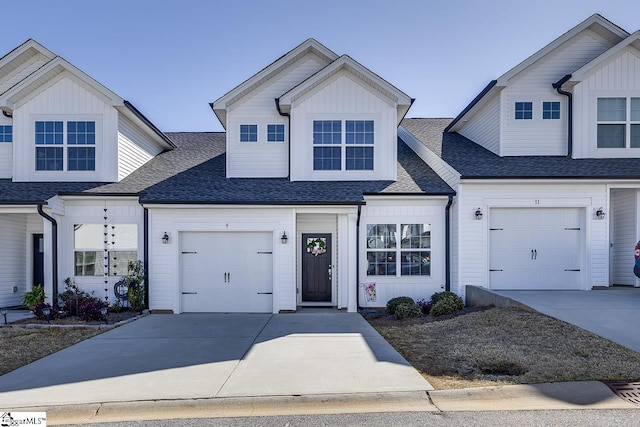 view of front of property with board and batten siding, driveway, a garage, and roof with shingles