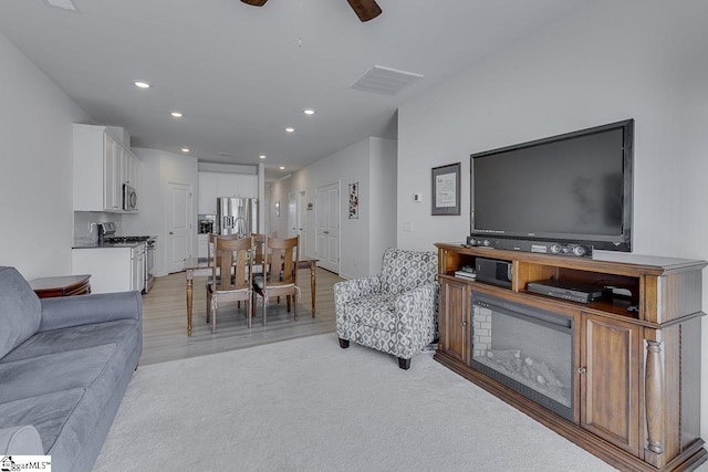 living room featuring visible vents, recessed lighting, a ceiling fan, and light wood finished floors