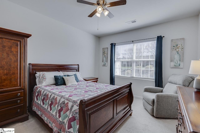 bedroom with light carpet, visible vents, and ceiling fan
