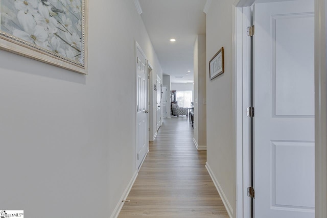 hall with baseboards, light wood-type flooring, and recessed lighting