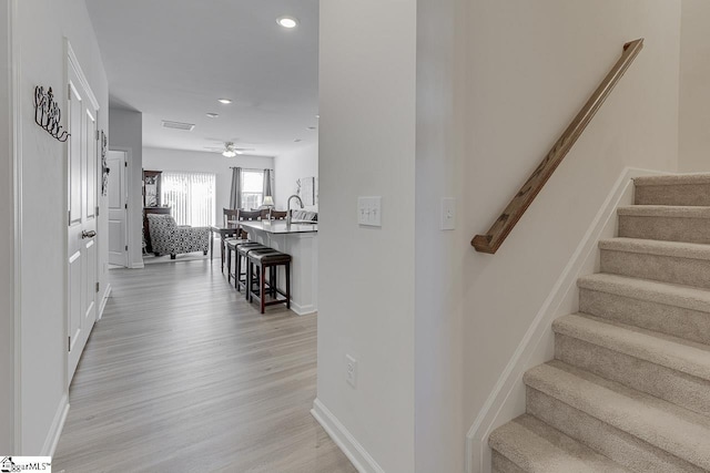 stairway featuring recessed lighting, baseboards, ceiling fan, and wood finished floors