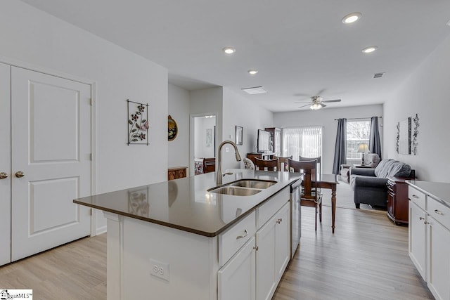 kitchen featuring white cabinets, light wood-style flooring, a sink, and ceiling fan