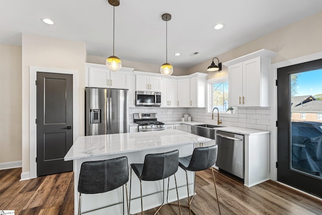 130 Park Ave, Greer, SC 29651 - kitchen with white cabinetry, a center island, backsplash, a sink, and appliances with stainless steel finishes