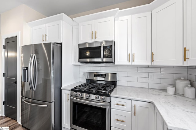 130 Park Ave, Greer, SC 29651 - kitchen featuring stainless steel appliances, decorative backsplash, light stone counters, white cabinets, and wood finished floors