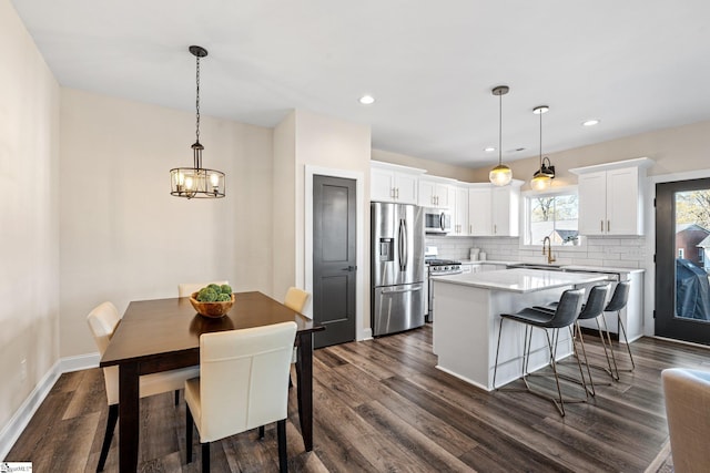 130 Park Ave, Greer, SC 29651 - kitchen featuring light countertops, dark wood-style flooring, backsplash, a kitchen island, and appliances with stainless steel finishes