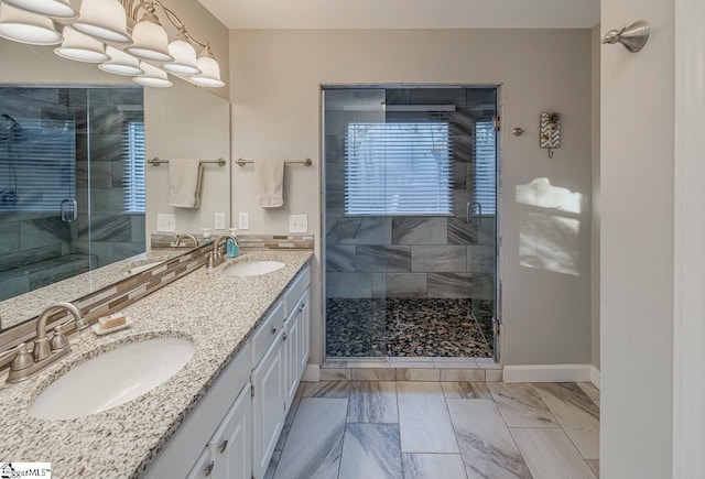 full bathroom featuring double vanity, a sink, and a shower stall