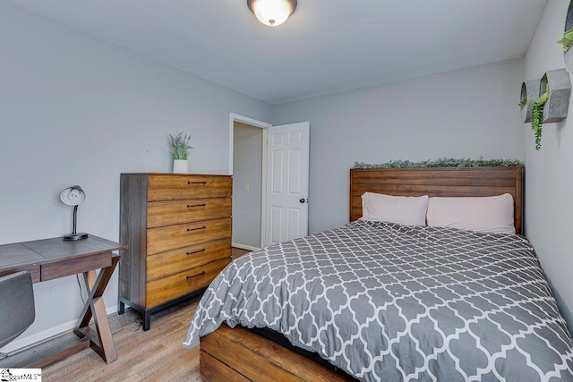 bedroom with baseboards and wood finished floors