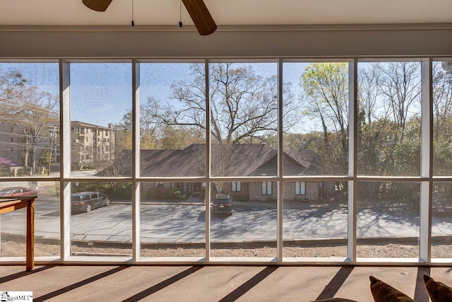 unfurnished sunroom with plenty of natural light and a ceiling fan