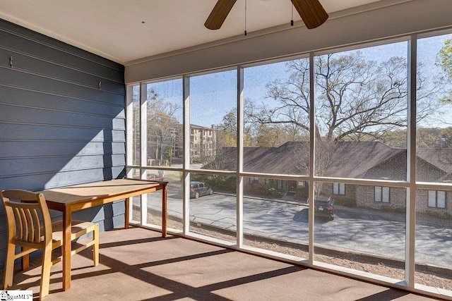 unfurnished sunroom featuring a ceiling fan
