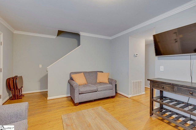 living area featuring light wood finished floors, baseboards, visible vents, and stairway