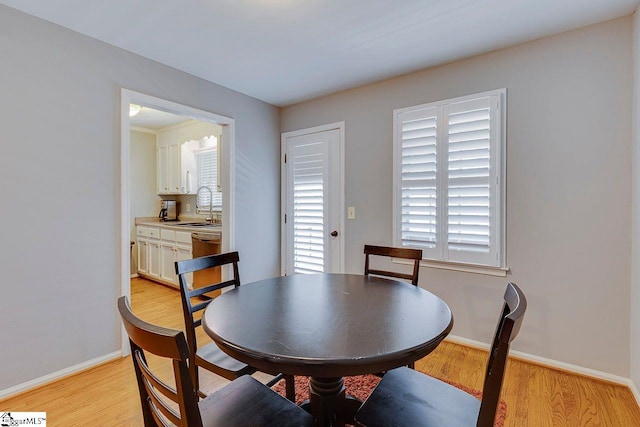 dining space with light wood-style flooring and baseboards