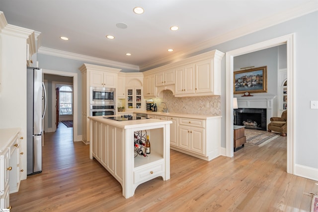 6 Bentford Ct, Simpsonville, SC 29681 - kitchen featuring light countertops, a fireplace, light wood-type flooring, stainless steel appliances, and decorative backsplash