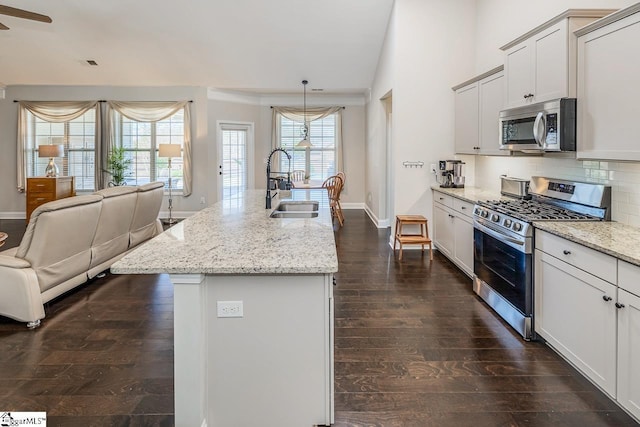 105 Cooper Oaks Ct, Simpsonville, SC 29681 - kitchen with open floor plan, decorative backsplash, a sink, light stone counters, and appliances with stainless steel finishes