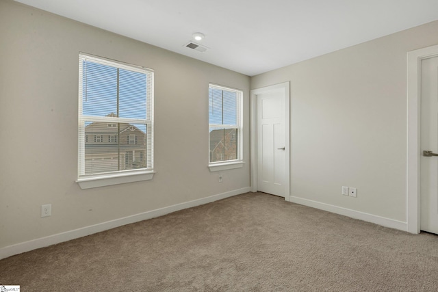 unfurnished bedroom with light colored carpet, visible vents, and baseboards