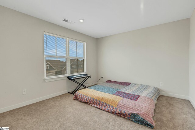 carpeted bedroom featuring baseboards and visible vents