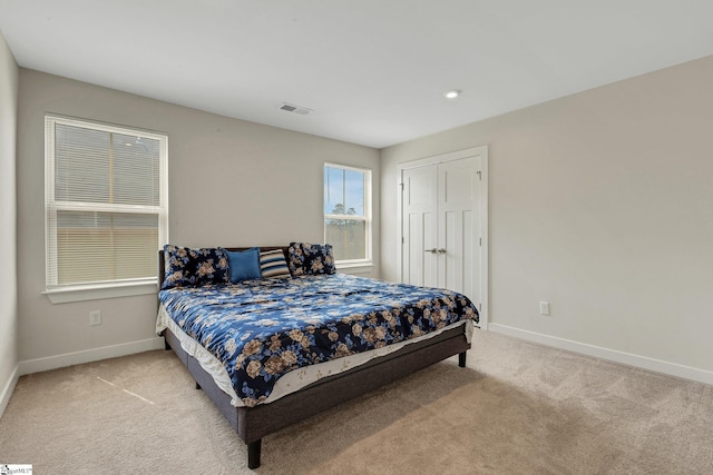 bedroom featuring baseboards, visible vents, and light carpet