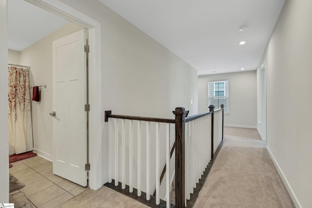 corridor featuring an upstairs landing, recessed lighting, baseboards, light tile patterned flooring, and light carpet