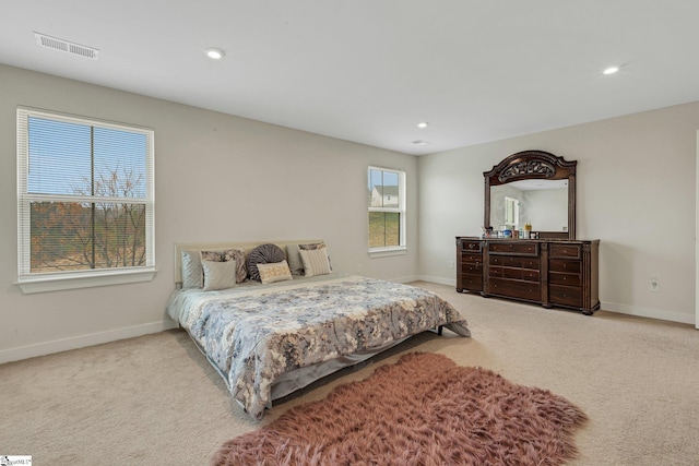 carpeted bedroom with baseboards, multiple windows, and visible vents
