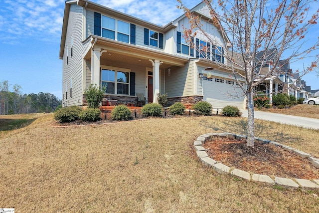 craftsman inspired home featuring a front yard, covered porch, stone siding, concrete driveway, and a garage