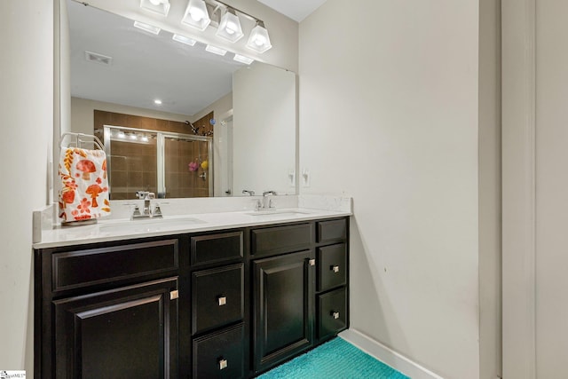 full bath with a shower stall, double vanity, visible vents, and a sink