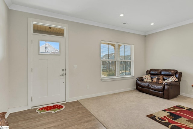 entryway with visible vents, crown molding, baseboards, recessed lighting, and light wood-style floors