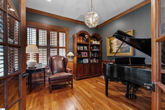 living area featuring ornamental molding, a chandelier, and wood finished floors