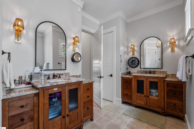 bathroom with ornamental molding, a sink, and two vanities