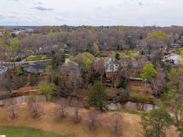 birds eye view of property with a water view and a wooded view