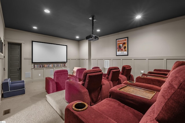 home theater featuring recessed lighting, carpet flooring, ornamental molding, visible vents, and a decorative wall