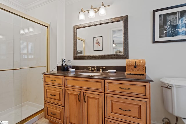 bathroom with a stall shower, toilet, vanity, and ornamental molding