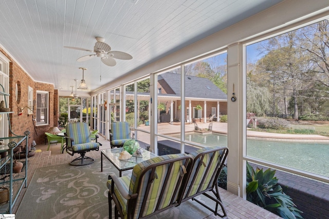 sunroom / solarium featuring a ceiling fan