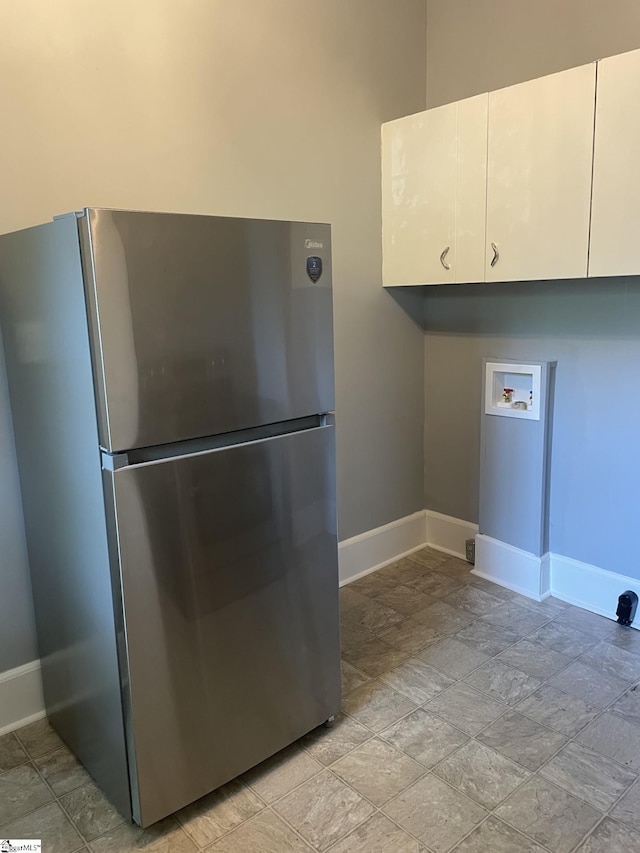 laundry area with cabinet space, washer hookup, and baseboards