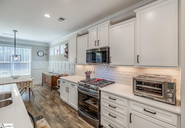 7 Ridgebury Pl, Greenville, SC 29607 - kitchen featuring crown molding, light countertops, appliances with stainless steel finishes, wainscoting, and visible vents