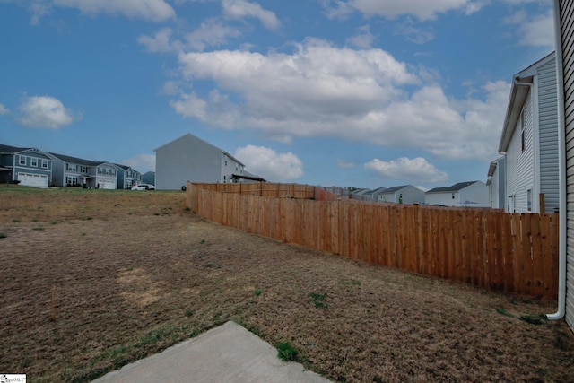 view of yard featuring fence and a residential view