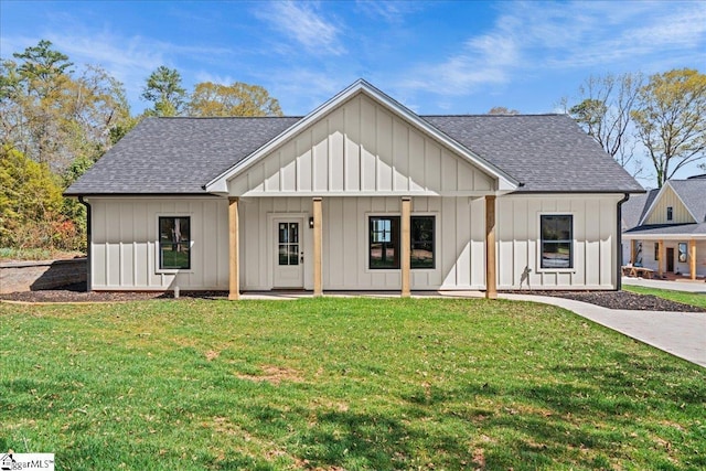modern farmhouse with a shingled roof, board and batten siding, a front yard, and a patio area