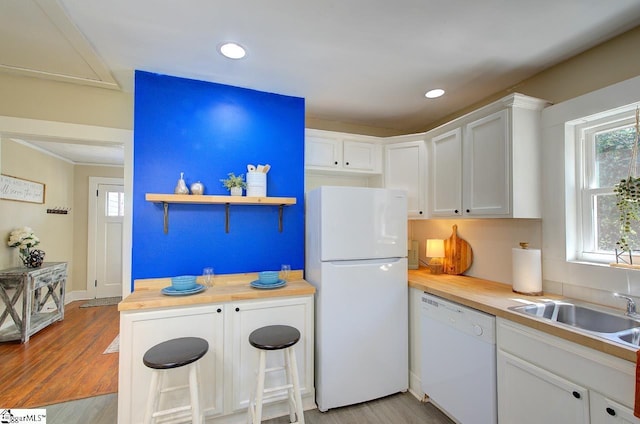 kitchen featuring wooden counters, light wood finished floors, white cabinets, and white appliances