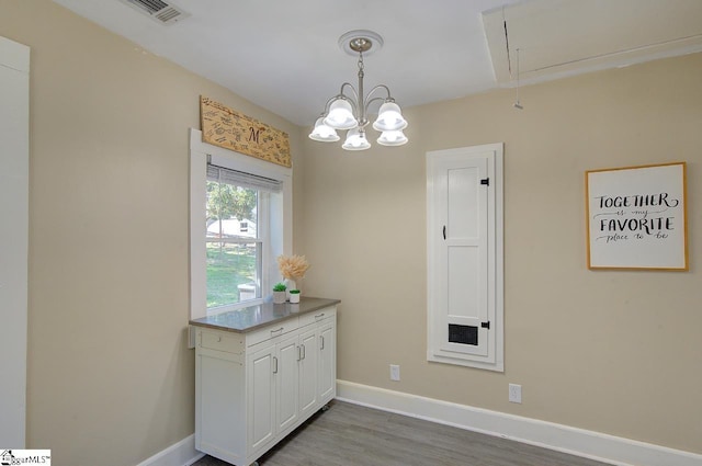 interior space with attic access, baseboards, visible vents, and wood finished floors